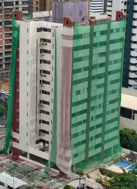 Edifício protegido com tela durante a obra — Edf. Pituba Porto Bello, Pituba